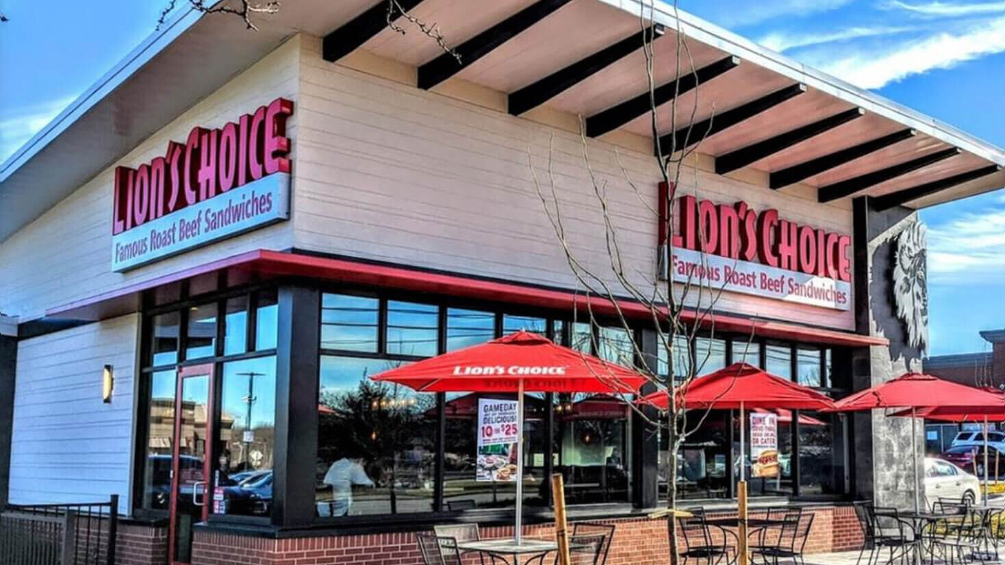 Image of a Lion's Choice Restaurant from the outside. There are three tables on the patio.