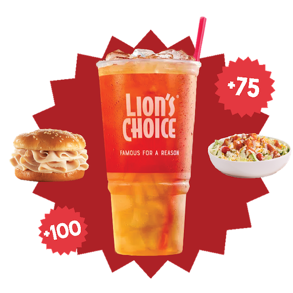 A drink in a plastic lion's choice cup with a sandwich to the left and salad to the right.